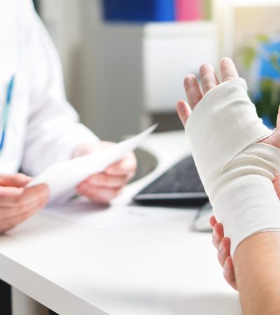 Injured,Patient,Showing,Doctor,Broken,Wrist,And,Arm,With,Bandage